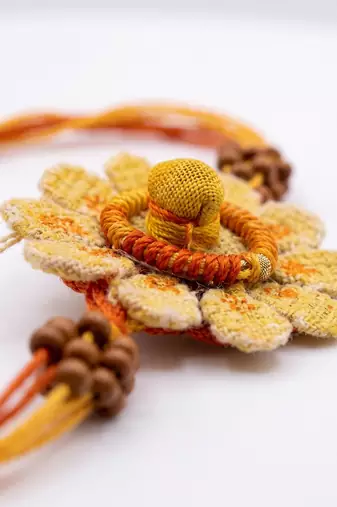 yellow floral seed thread rakhi with roli chawal chandan mishri