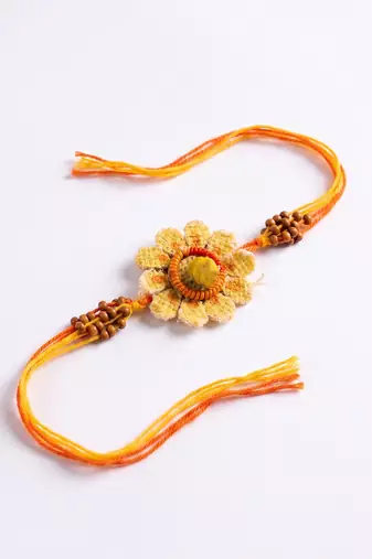 yellow floral seed thread rakhi with roli chawal chandan mishri