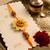 yellow floral seed thread rakhi with roli chawal chandan mishri
