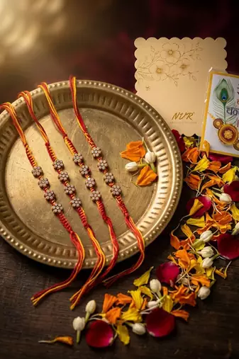 set of 4 artificial stones floral design thread rakhi with roli chawal chandan mishri