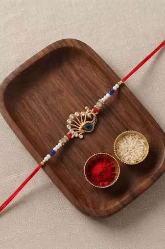 peacock design rakhi with roli chawal and raksha bandhan card