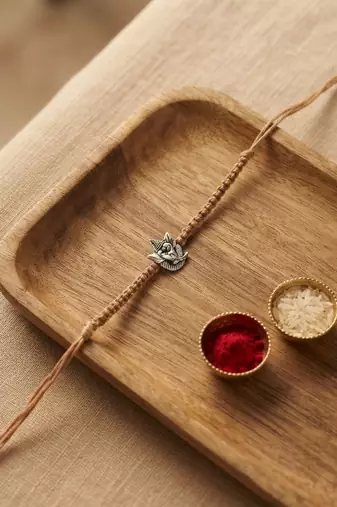 ganesha design rakhi with roli chawal and raksha bandhan card