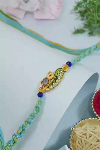 peacock feather designer rakhi with roli chawal and raksha bandhan card