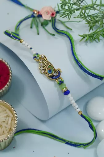 peacock feather designer rakhi with roli chawal and raksha bandhan card