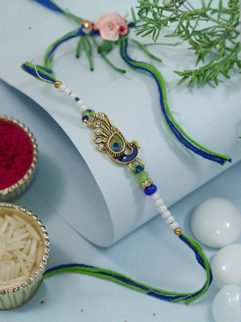 peacock feather designer rakhi with roli chawal and raksha bandhan card