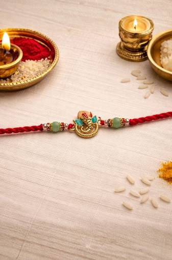 ganesha designer red rakhi with roli chawal and raksha bandhan card