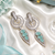 Rhodium finish mint halo drop earrings