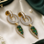 Gold finish emerald halo drop earrings