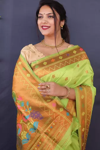Light green banarasi silk blend saree with copper zari butti & geometric woven border