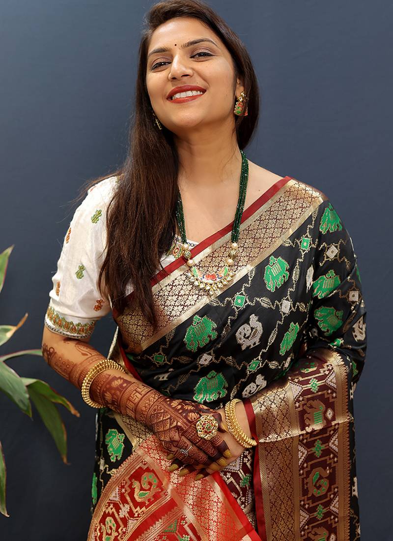 Black silk blend patola saree with zari border and contrast red pallu