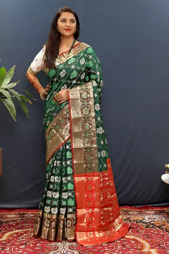 Dark green silk blend patola saree with zari border and contrast red pallu