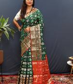 Dark green silk blend patola saree with zari border and contrast red pallu