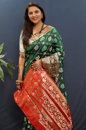 Dark green silk blend patola saree with zari border and contrast red pallu