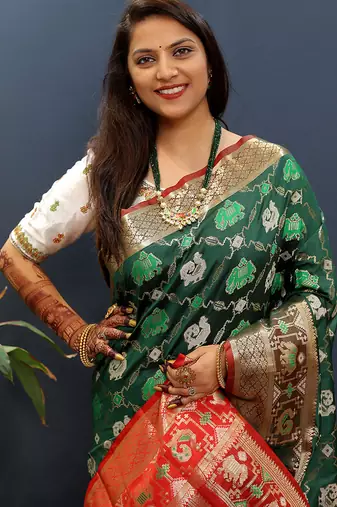 Dark green silk blend patola saree with zari border and contrast red pallu