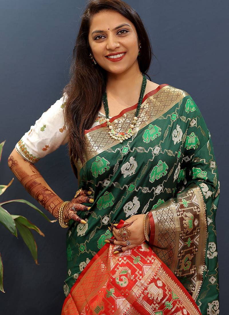 Dark green silk blend patola saree with zari border and contrast red pallu