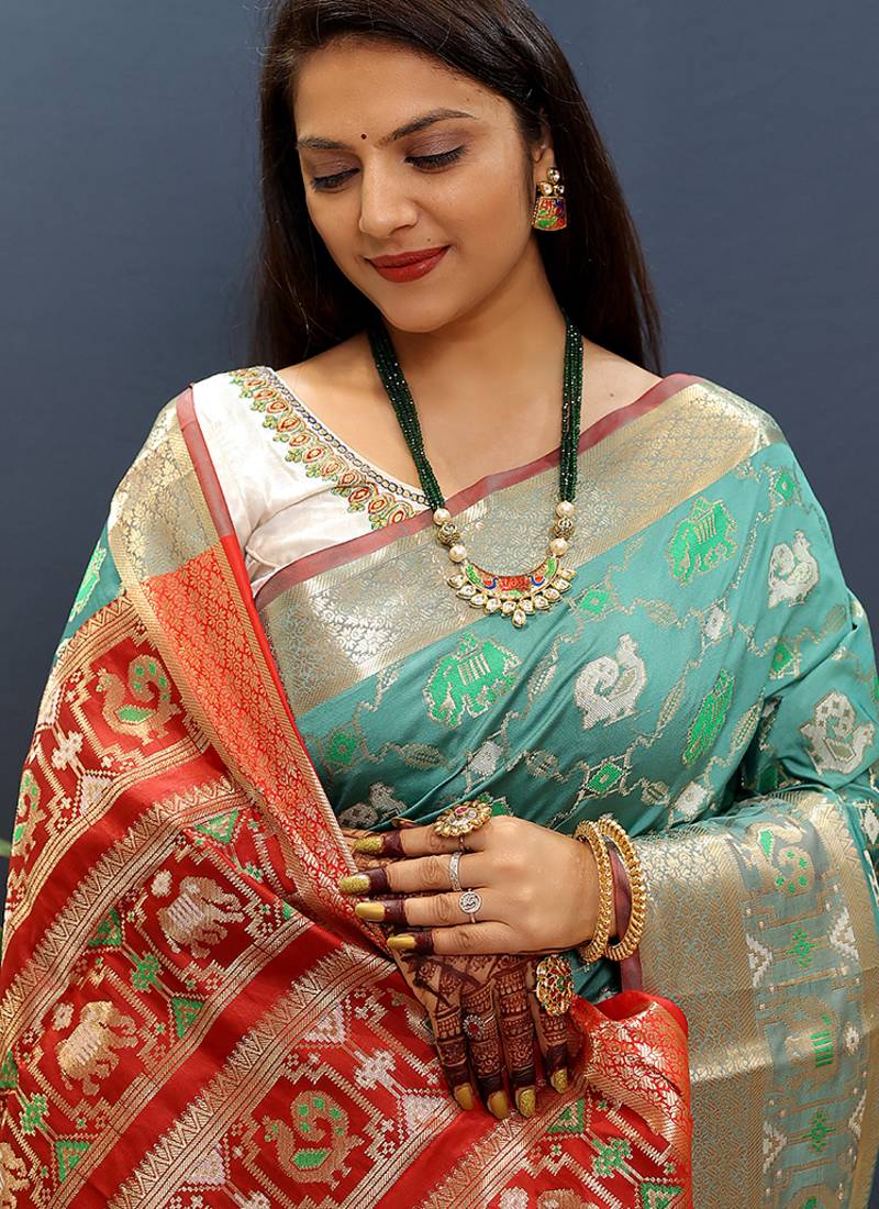 Turquoise silk blend patola saree with zari border and contrast red pallu