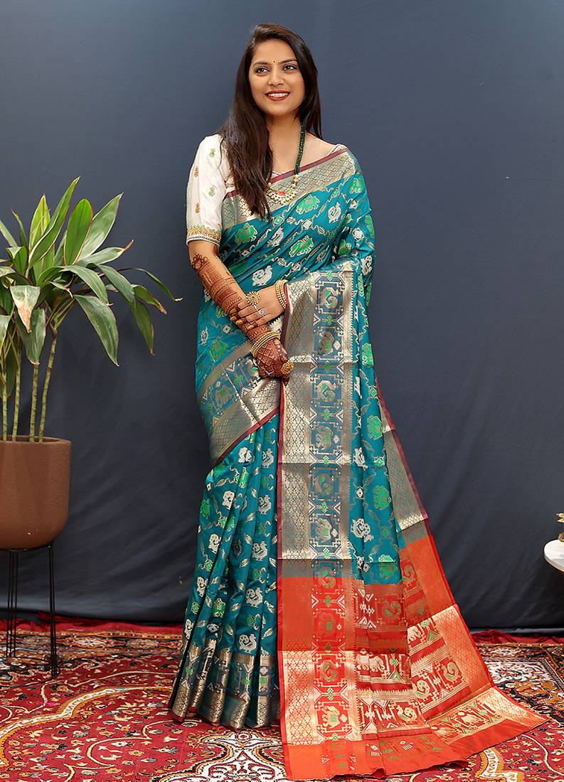 Teal blue silk blend patola saree with zari border and contrast red pallu
