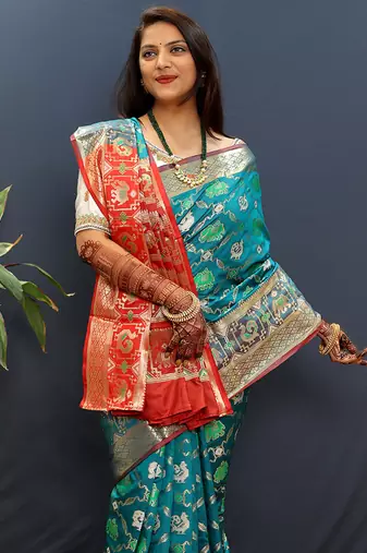 Teal blue silk blend patola saree with zari border and contrast red pallu