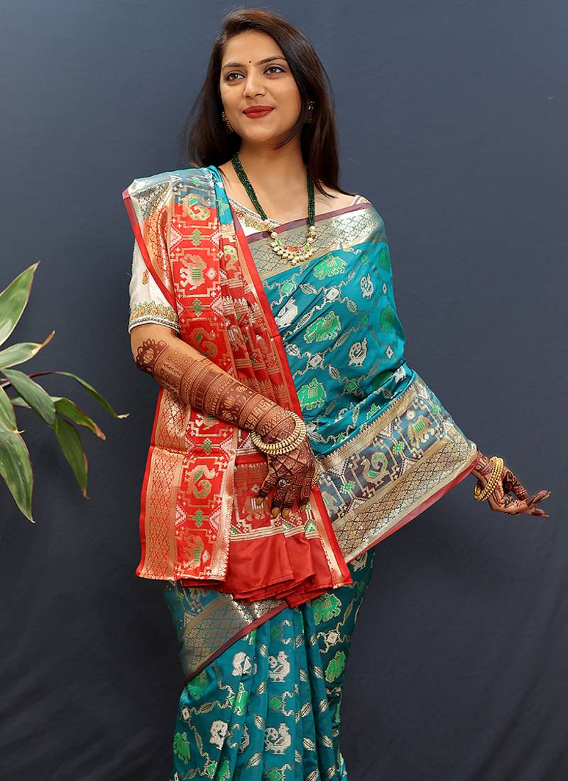 Teal blue silk blend patola saree with zari border and contrast red pallu