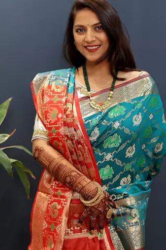 Teal blue silk blend patola saree with zari border and contrast red pallu