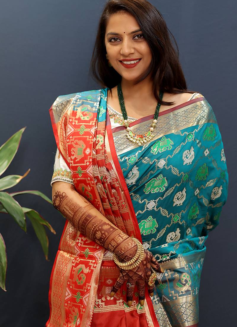 Teal blue silk blend patola saree with zari border and contrast red pallu