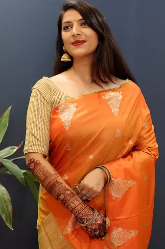 Orange silk blend banarasi saree with golden zari buti and border