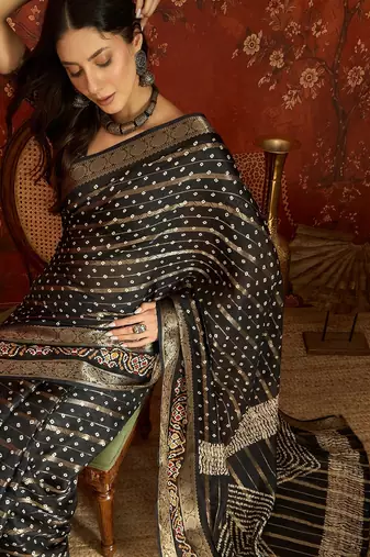 Black silk cotton bandhni saree with unstitched blouse piece.