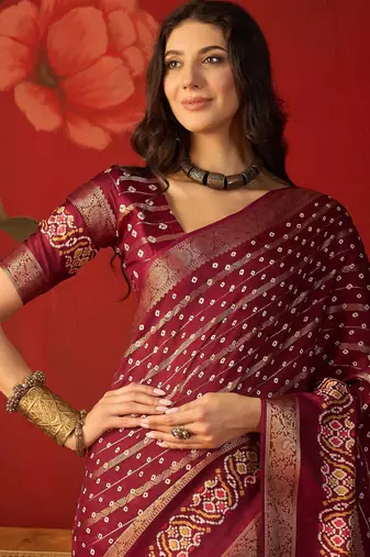 Maroon silk cotton bandhni saree with unstitched blouse piece.
