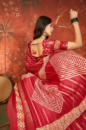 Red silk cotton bandhni saree with unstitched blouse piece.