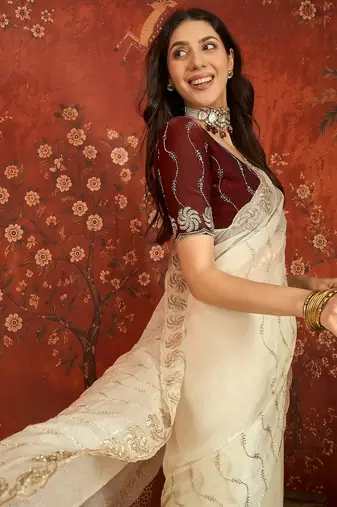 Cream tissue embroidered saree with unstitched blouse piece.