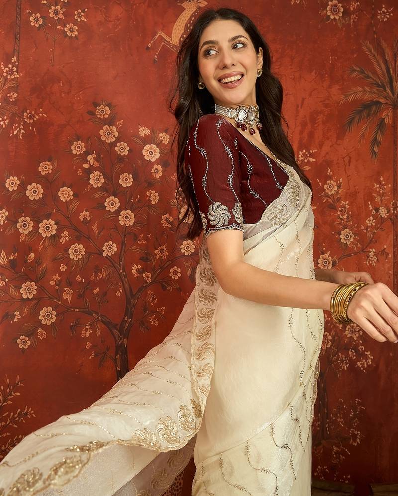 Cream tissue embroidered saree with unstitched blouse piece.