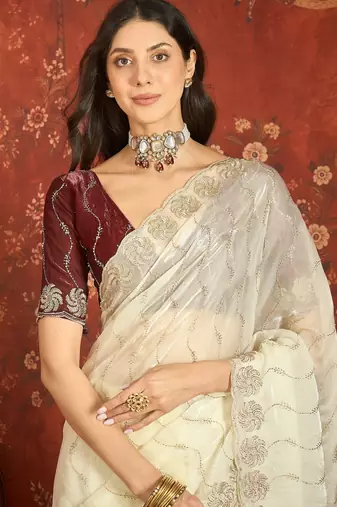 Cream tissue embroidered saree with unstitched blouse piece.