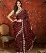 Maroon tissue embroidered saree with unstitched blouse piece.