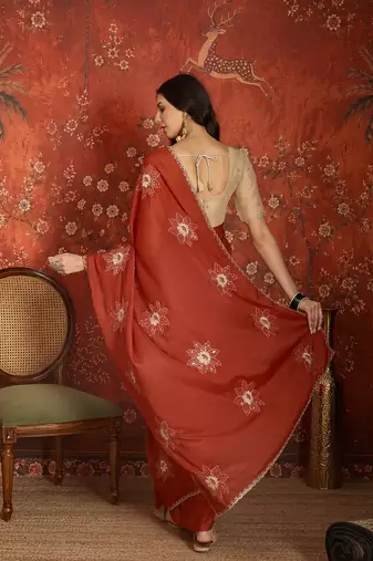 Rust chiffon embroidered saree with unstitched blouse piece.