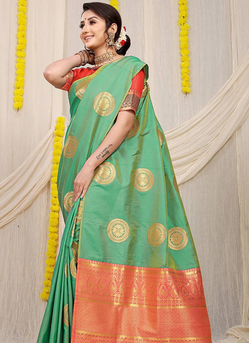 Sea green silk blend saree with pink zari border and circular motifs