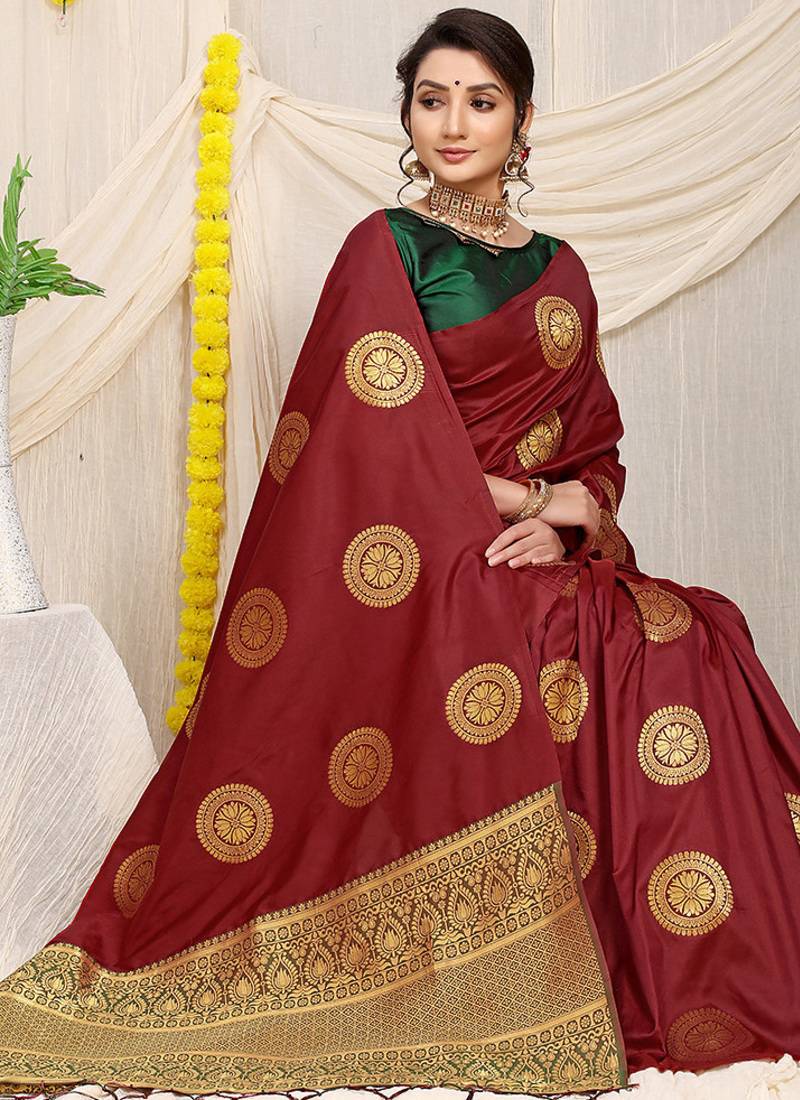 Maroon silk blend saree with dark green zari border and circular motifs