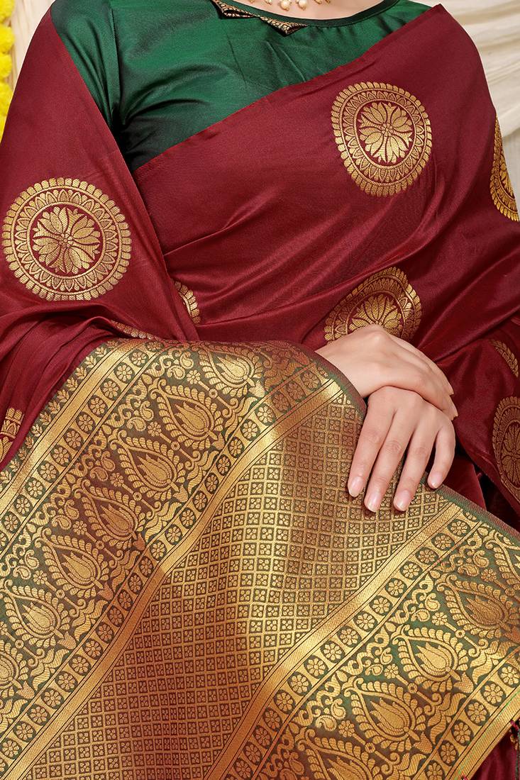 Maroon silk blend saree with dark green zari border and circular motifs