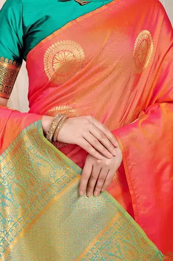 Peach silk blend saree with turquoise zari border and circular motifs