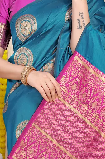 Teal blue silk blend saree with magenta pink zari border and circular motifs