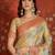 Beige tissue woven design saree with unstitched blouse piece.
