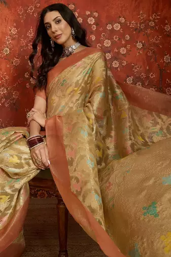 Beige tissue woven design saree with unstitched blouse piece.
