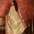 Beige tissue woven design saree with unstitched blouse piece.