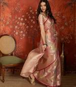 Pink tissue woven design saree with unstitched blouse piece.