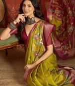Green silk cotton printed saree with unstitched blouse piece.