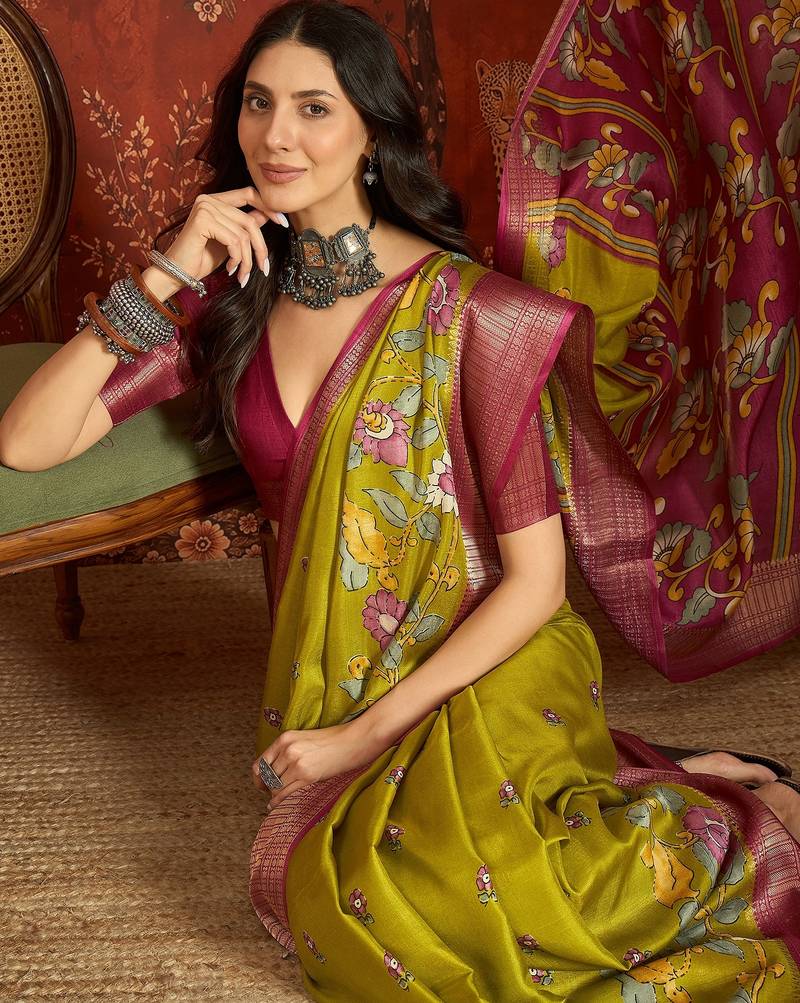Green silk cotton printed saree with unstitched blouse piece.