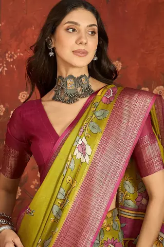Green silk cotton printed saree with unstitched blouse piece.