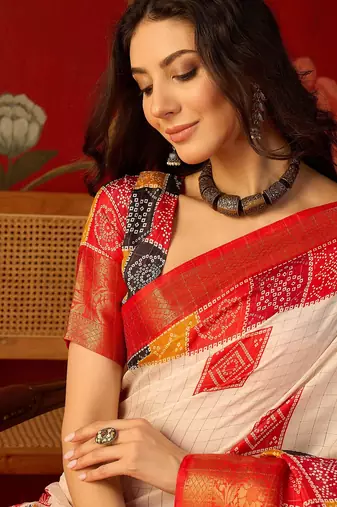 Cream silk cotton bandhni saree with unstitched blouse piece.