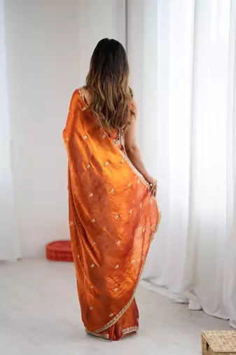 Orange tissue satin embroidered saree with unstitched blouse piece.