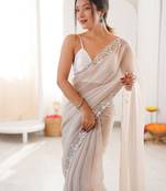 Cream chiffon embellished saree with unstitched blouse piece.