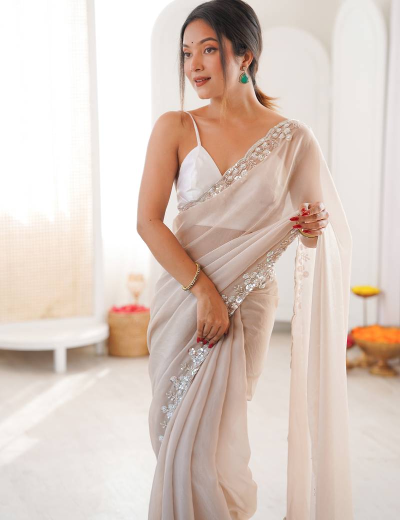Cream chiffon embellished saree with unstitched blouse piece.